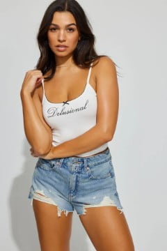  Model wears a white graphic tank top and denim shorts.