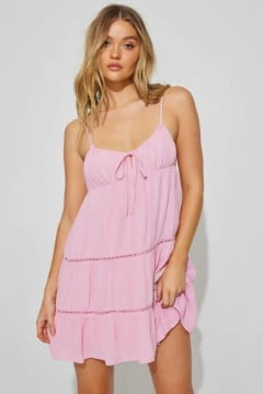 Model wears a pink baby doll dress.