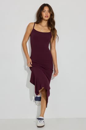 Model wears a burgundy maxi dress with sneakers.