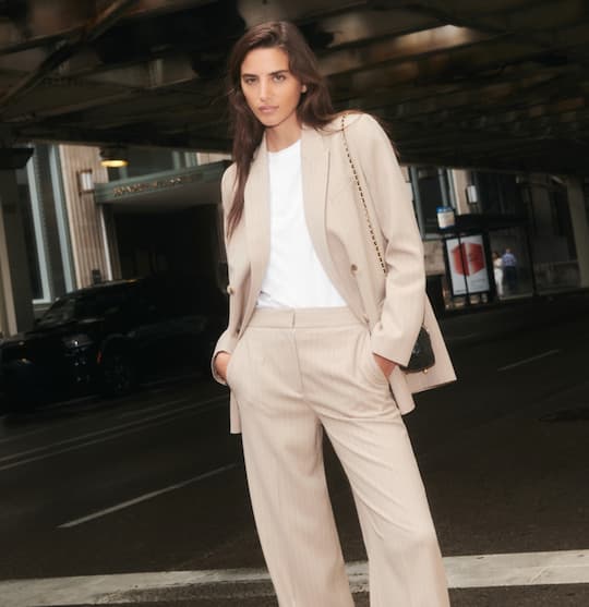 Model is wearing a beige blazer and beige pants on sale.