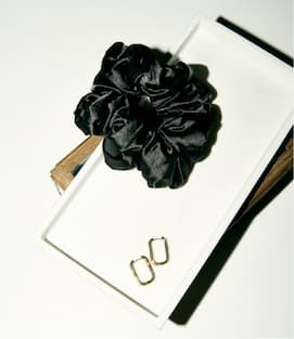 Black satin pillow scrunchie on table.